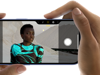 Uživatel drží iPhone 16 a fotí snímek